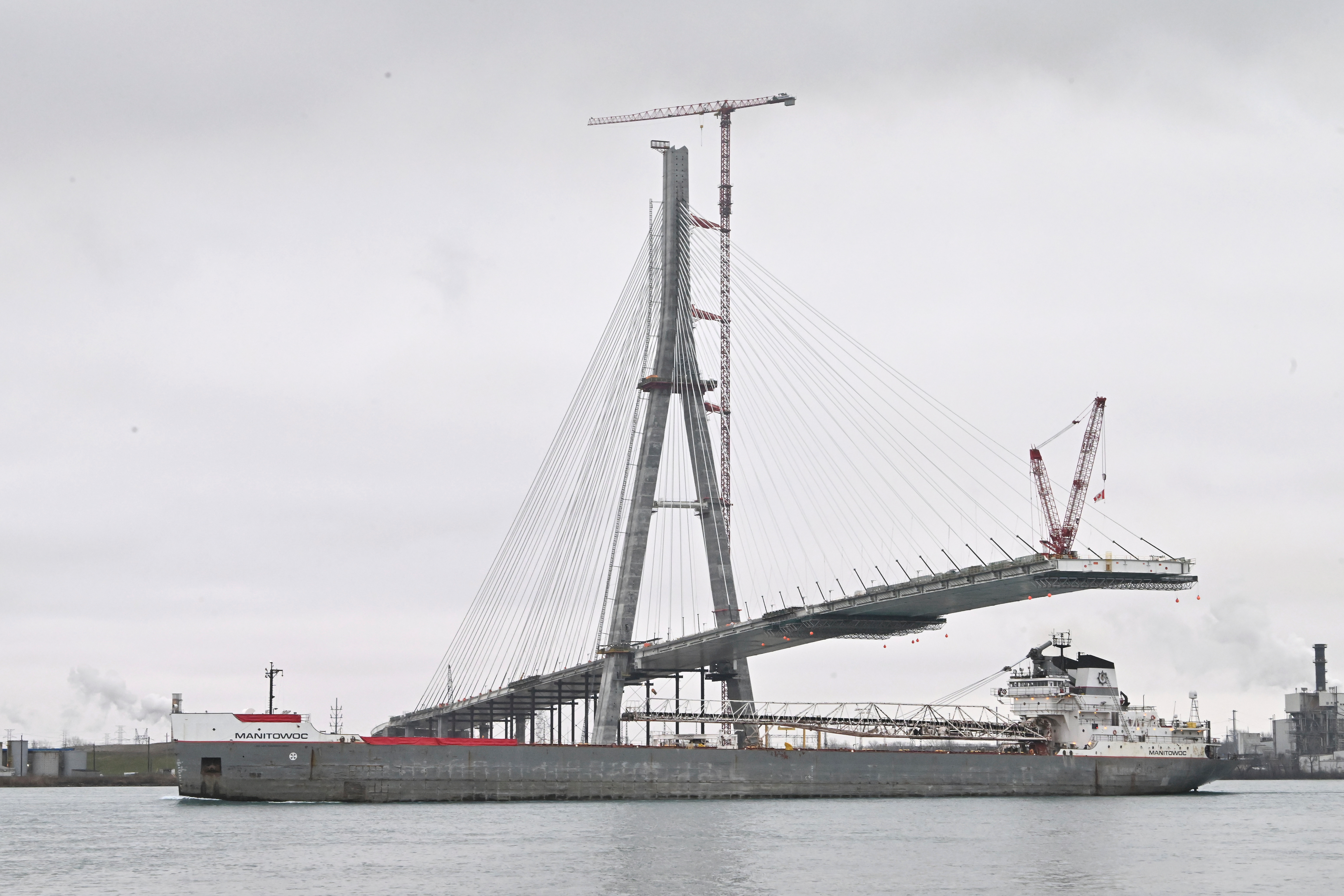 The freighter Manitowoc passes by construction on the Gordie Howe International Bridge, Detroit, Dec. 29, 2023.
