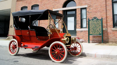 A 1909 Model T in front of the factory where it was made, the Ford Piquette Avenue Plant.