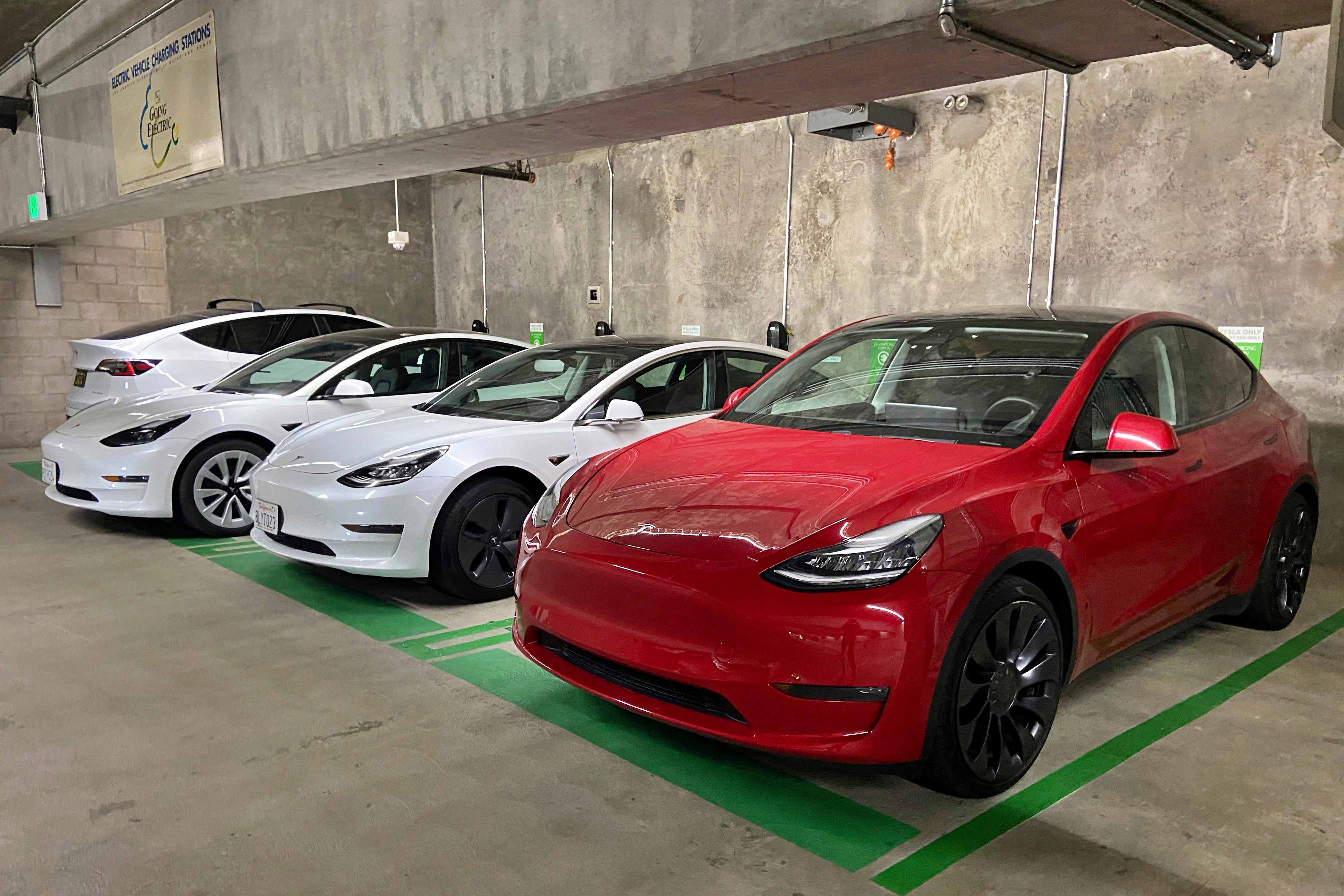 This photo provided by Edmunds shows a line of parked Tesla Model 3 and Model Y vehicles.