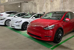 This photo provided by Edmunds shows a line of parked Tesla Model 3 and Model Y vehicles.
