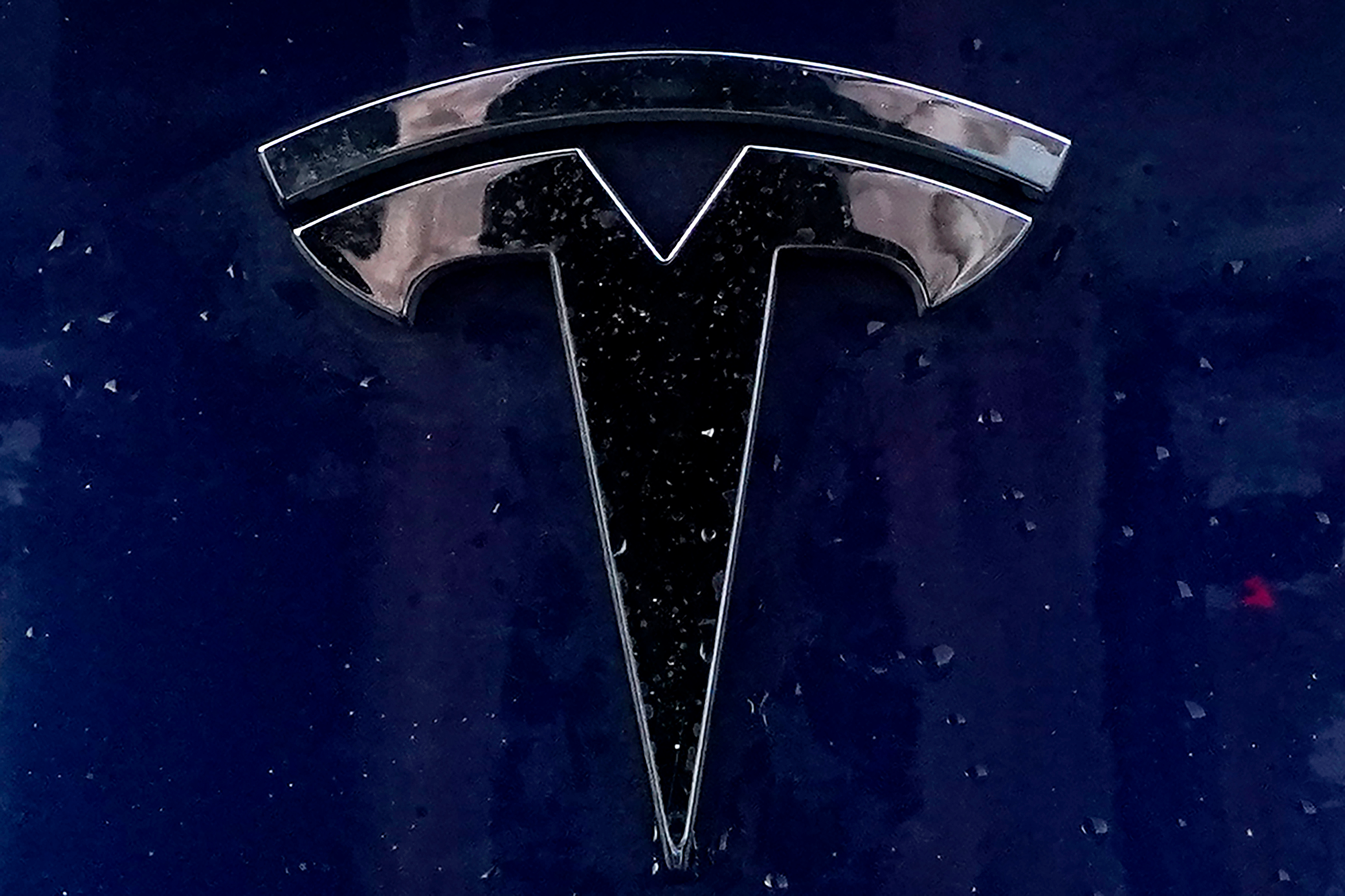 A Tesla electric vehicle emblem is affixed to a passenger vehicle Sunday, Feb. 21, 2021, in Boston.