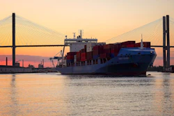 A commercial cargo ship as it leaves the Port of Savannah in Georgia at sunset.