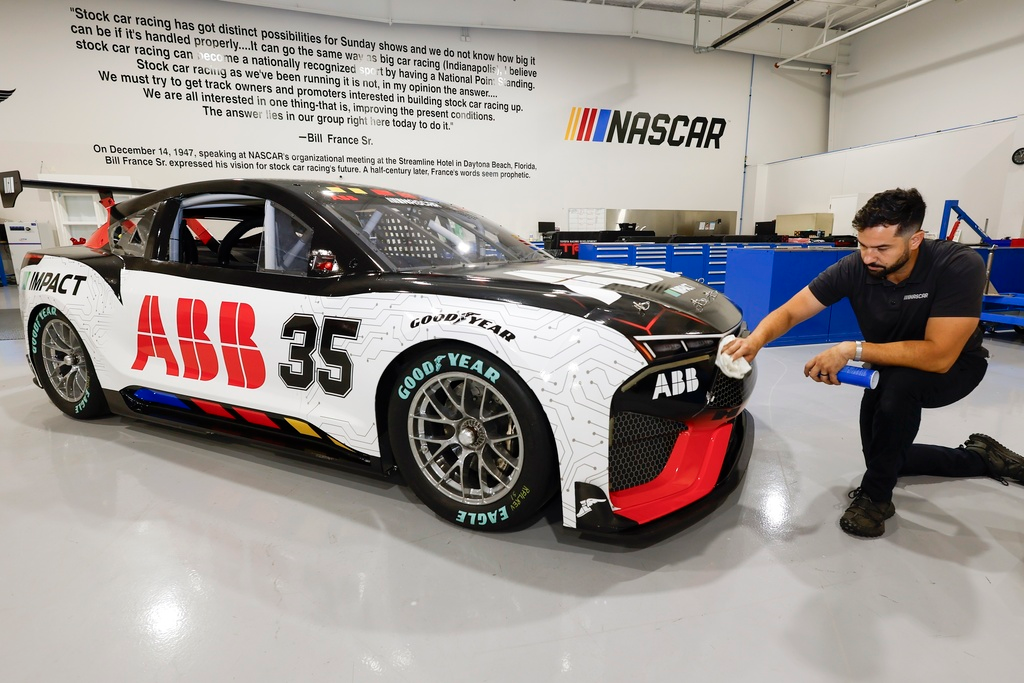 CJ Tobin, senior engineer of vehicle systems, cleans a prototype of the first electric racecar at the NASCAR R&D Center in Concord, N.C., Monday, July 1, 2024. The top motorsports series in North America partnered with Chevrolet, Ford, Toyota and electrification company ABB to demonstrate a high-performance electric vehicle and gauge fan interest in electric racing.