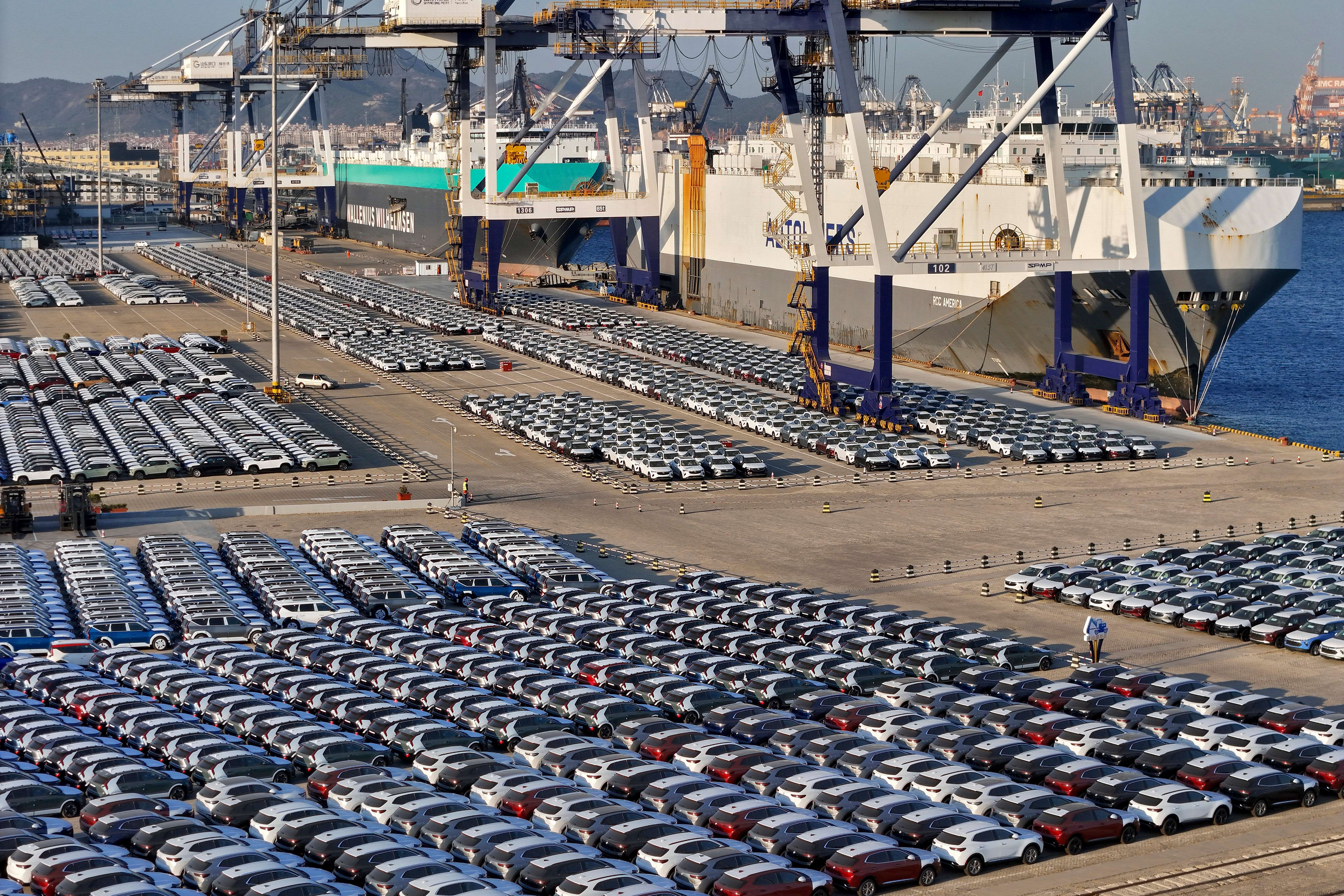 New cars for export wait for transportation on a vehicles carrier vessel at a dockyard in Yantai in east China's Shandong province.