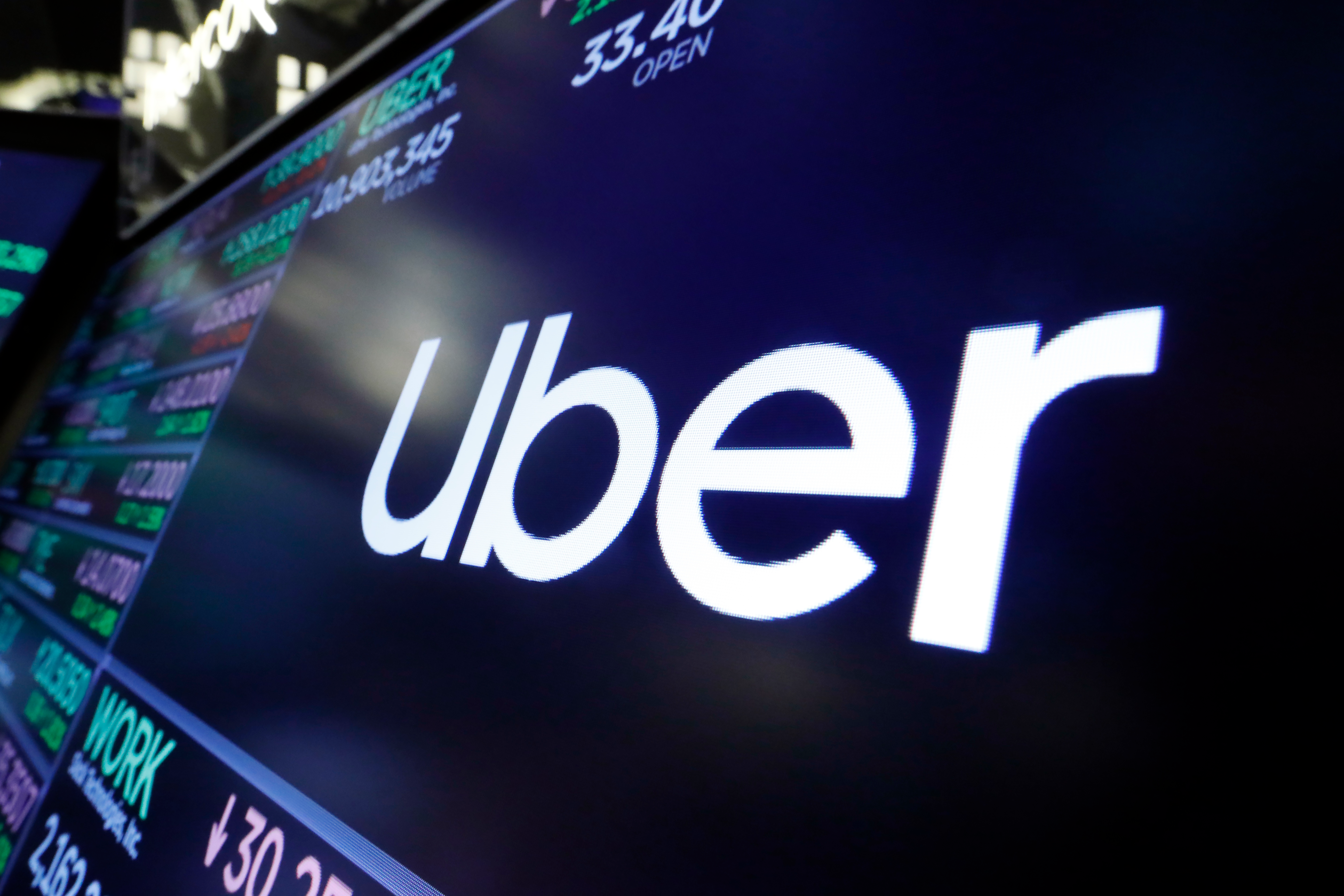 The Uber logo appears above a trading post on the floor of the New York Stock Exchange.