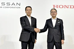 Nissan Chief Executive Makoto Uchida, left, and Honda Chief Executive Toshihiro Mibe shake hands during a joint news conference in Tokyo, Thursday.