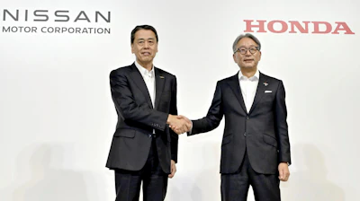 Nissan Chief Executive Makoto Uchida, left, and Honda Chief Executive Toshihiro Mibe shake hands during a joint news conference in Tokyo, Thursday.