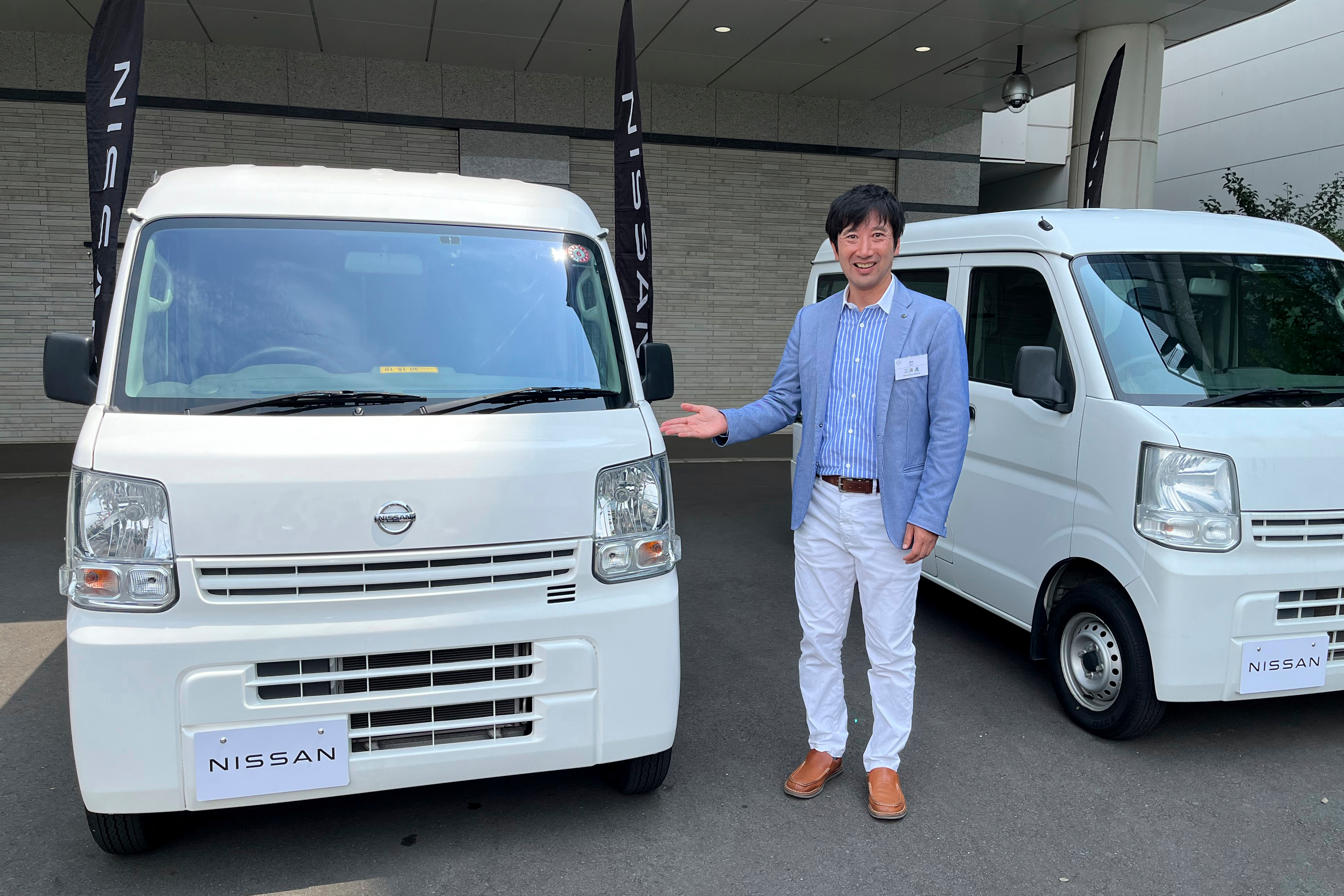 Susumu Miura, a Nissan Research Center manager, shows a Nissan car that is coated with the special “cool paint,” under testing at Tokyo’s Haneda airport.