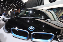 A worker cleans an electric vehicle at the BMW booth during the Auto Shanghai 2019 show in Shanghai on April 17, 2019.