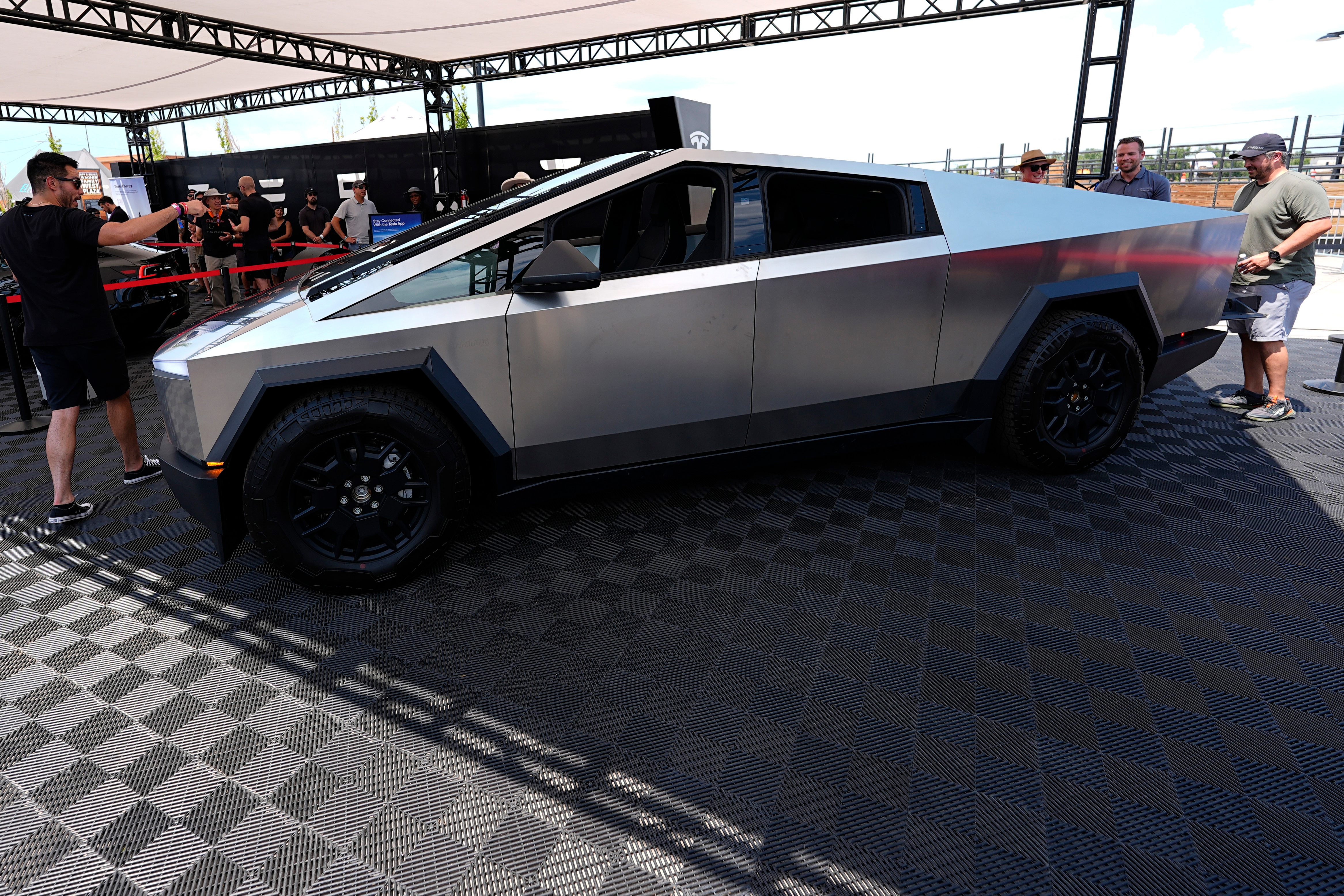 Visitors look over a 2024 Cybertruck in the Tesla display at the Electrify Expo, July 14, 2024, in north Denver.