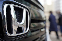 People walk near the logo of Honda Motor Company at a showroom on Feb. 8, 2022, in Tokyo.