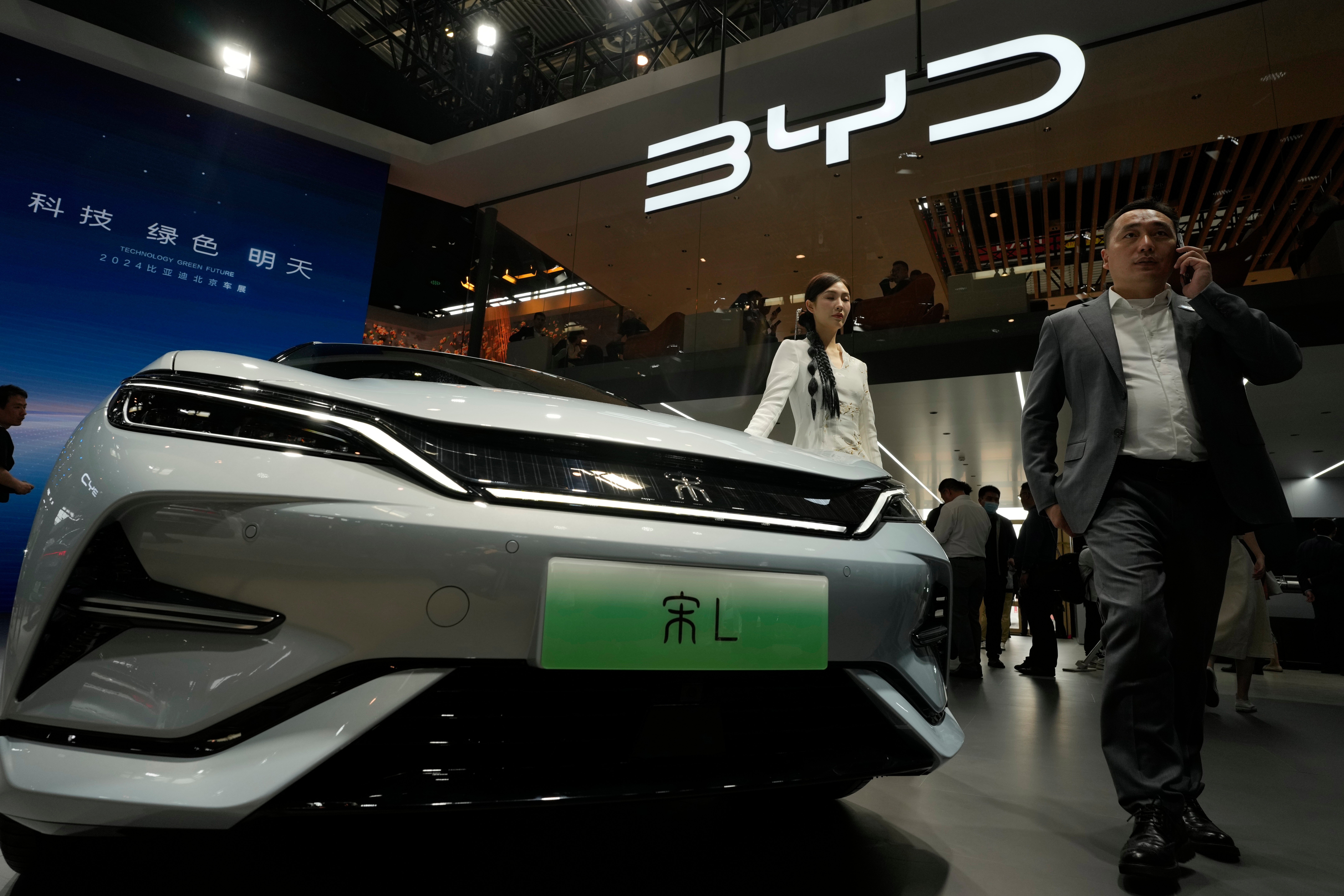 A model poses near the BYD Song L EV car during Auto China 2024 held in Beijing, April 25, 2024.