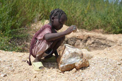 Juliet Samaniya, 6, chips at a rock with a stone tool at an illegal lithium mining site in Paseli, Nigeria, Tuesday, Nov 5, 2024.