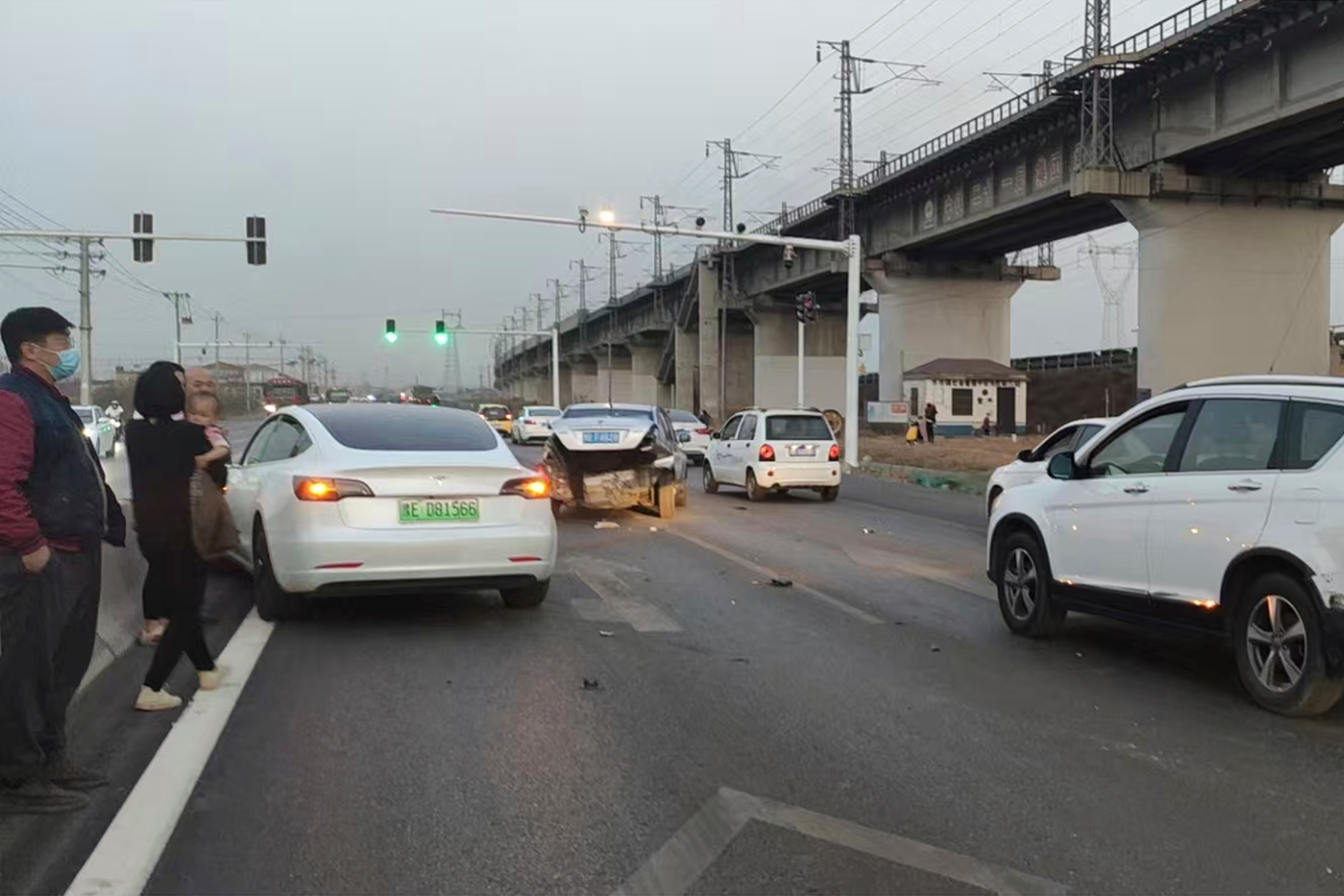 This photo provided by Zhang Yazhou shows her damaged Tesla Model 3, left, which her father was driving when it hit two other cars before crashing to a halt against a concrete barrier in Anyang, a city in central China’s Henan province, on Feb. 21, 2021. Zhang was in the passenger seat. Her mother and her one-year-old niece were at the back.