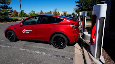 A Tesla Model 3 charges at a Tesla supercharging station situated in the parking lot of an outlet mall on Sept. 25, 2024, in Lakewood, Colo.