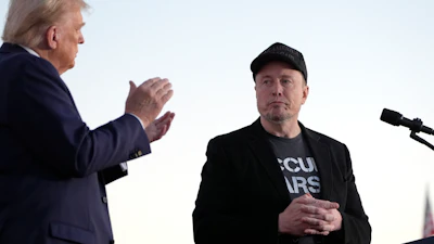 Republican presidential nominee former President Donald Trump, left, claps as Tesla and SpaceX CEO Elon Musk prepares to depart after speaking at a campaign event at the Butler Farm Show, on Oct. 5, 2024, in Butler, Pa.