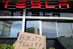 A banner is left outside a Tesla showroom during a demonstration, in Lisbon, Sunday, March 9, 2025.
