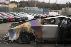 A member of the Seattle Fire Department inspects a burned Tesla Cybertruck at a Tesla lot in Seattle, Monday, March 10, 2025.