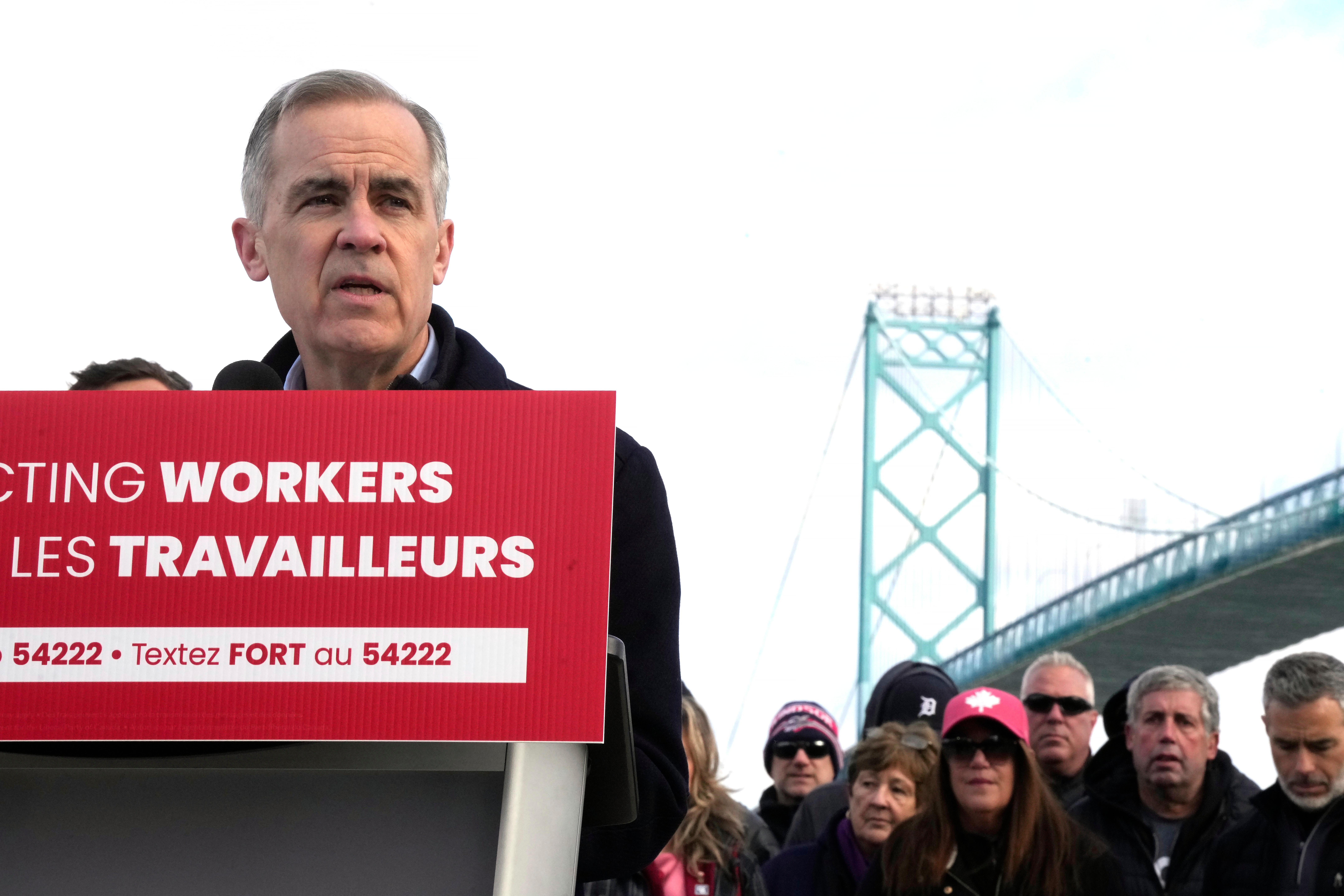 Unifor auto workers stand behind Liberal Leader Mark Carney as he speaks during a campaign stop at the Ambassador Bridge in Windsor, Ont., on Wednesday, March 26, 2025.