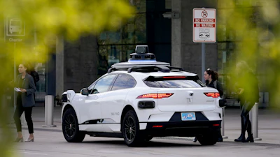 A Waymo self-driving vehicle sits curbside on Dec. 16, 2022, at the Sky Harbor International Airport Sky Train facility in Phoenix.