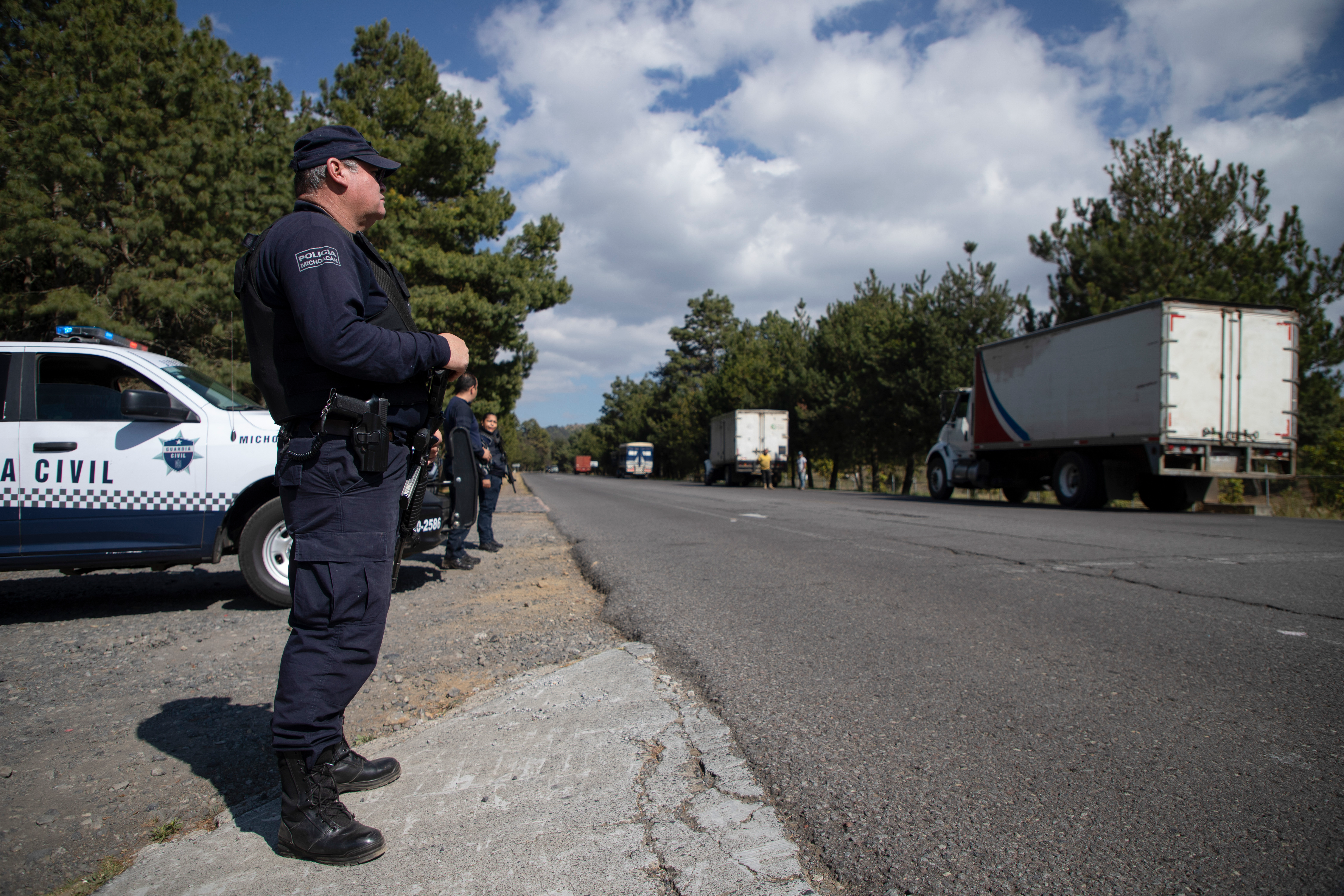 Police guard trucks loaded with avocados on their way to the city of Uruapan in Santa Ana Zirosto, Michoacan state, Mexico, Jan. 26, 2023.