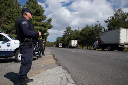 Police guard trucks loaded with avocados on their way to the city of Uruapan in Santa Ana Zirosto, Michoacan state, Mexico, Jan. 26, 2023.