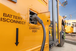 An electric school bus being charged.