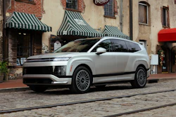 Silver Hyundai IONIQ 5 electric SUV parked on cobblestone street with brick buildings