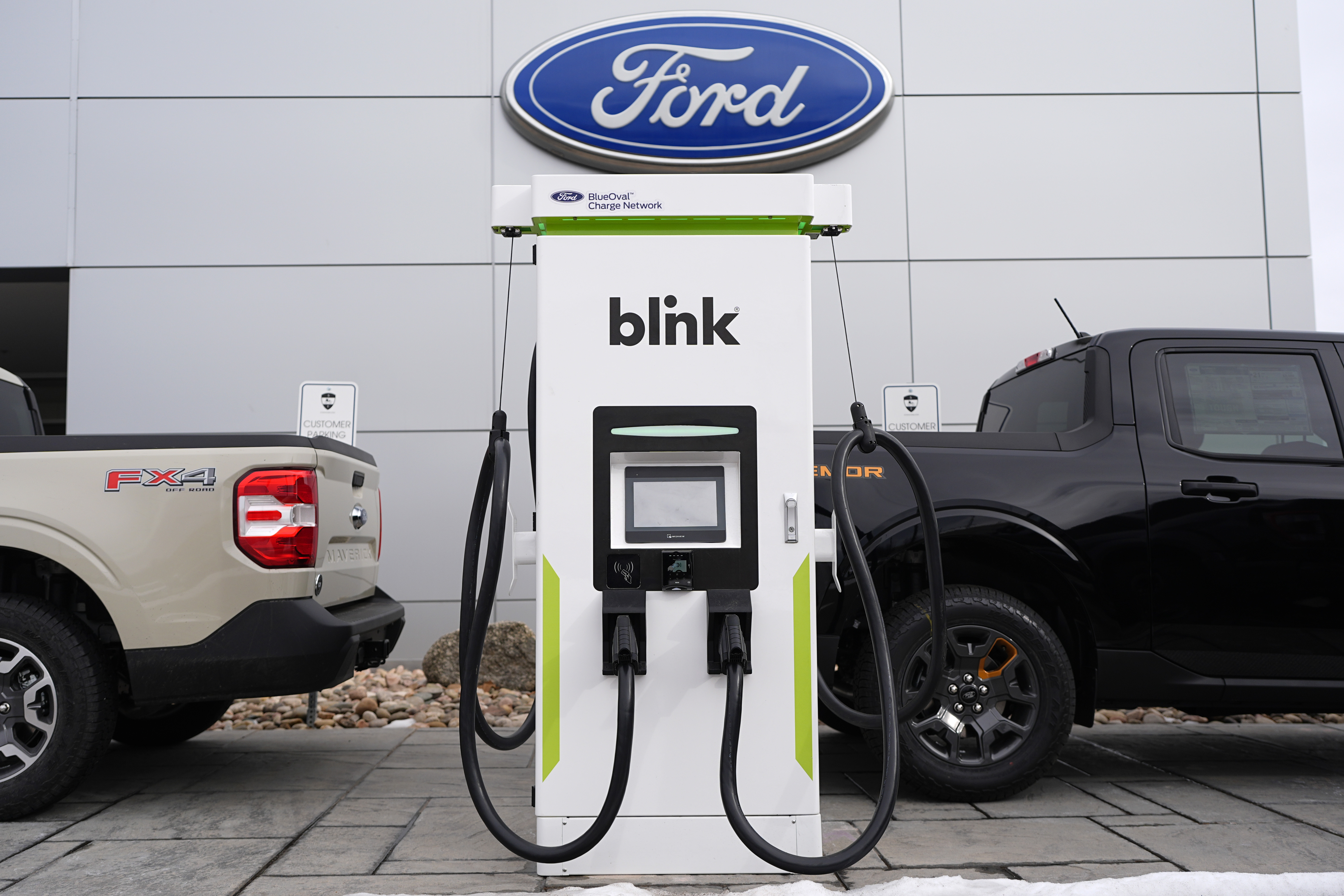 Ford electric vehicle charging station with Blink charger between two Ford trucks