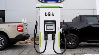 Ford electric vehicle charging station with Blink charger between two Ford trucks