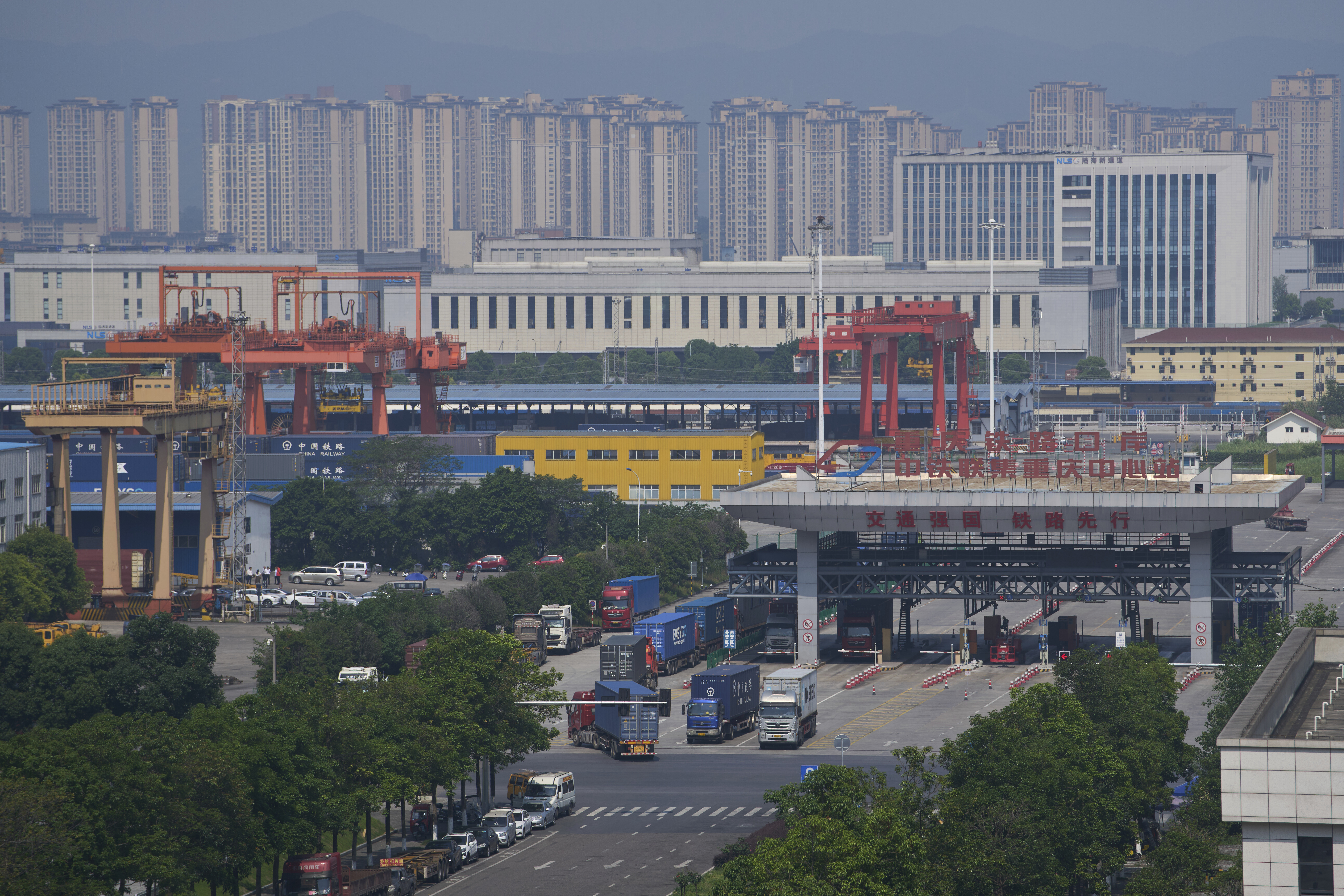 Urban industrial landscape with gantry cranes, highway, and high-rise buildings in background