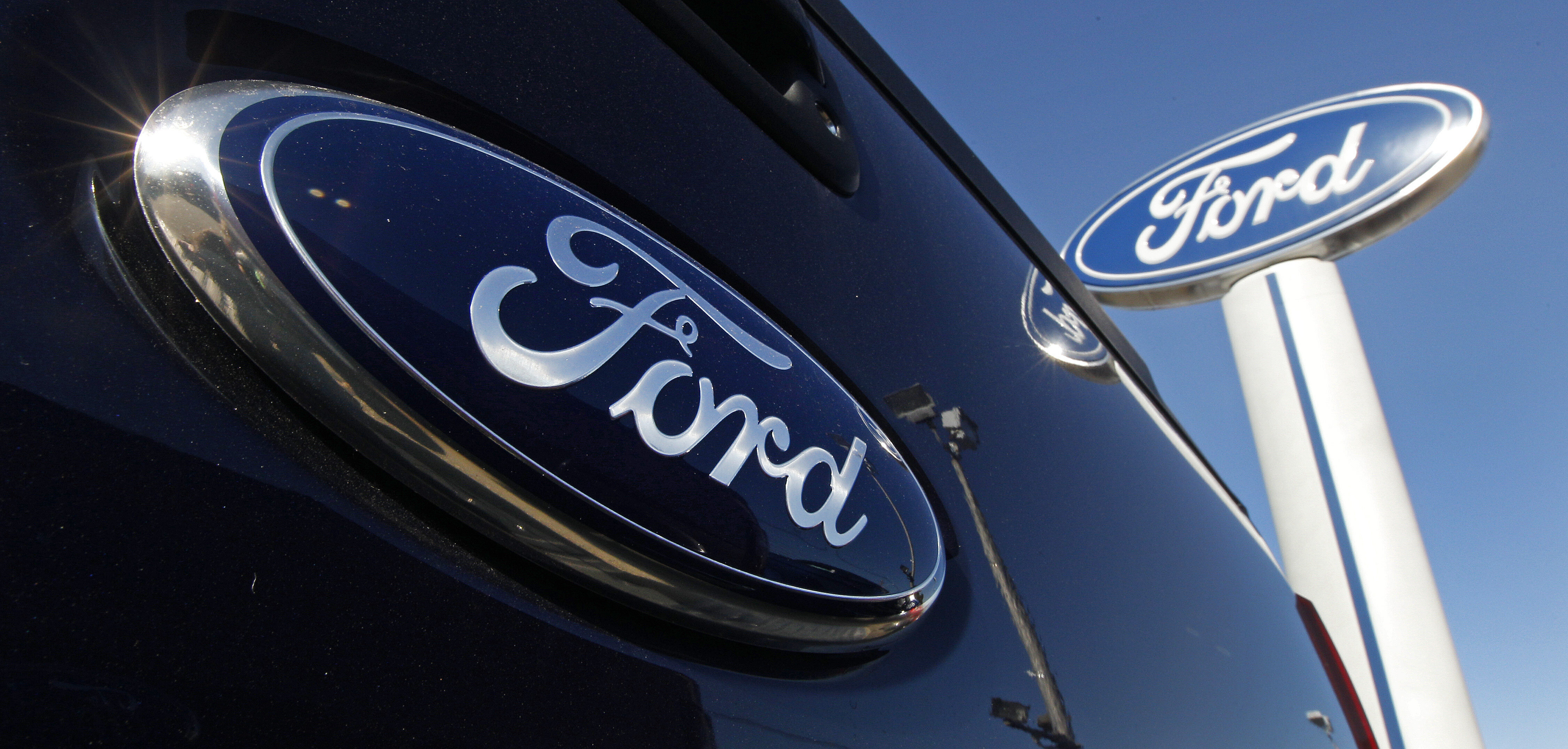 Ford automotive logo in dark blue on glossy vehicle surface