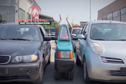 Three vehicles parked tightly in a parking lot, with a small vehicle squeezed between two cars