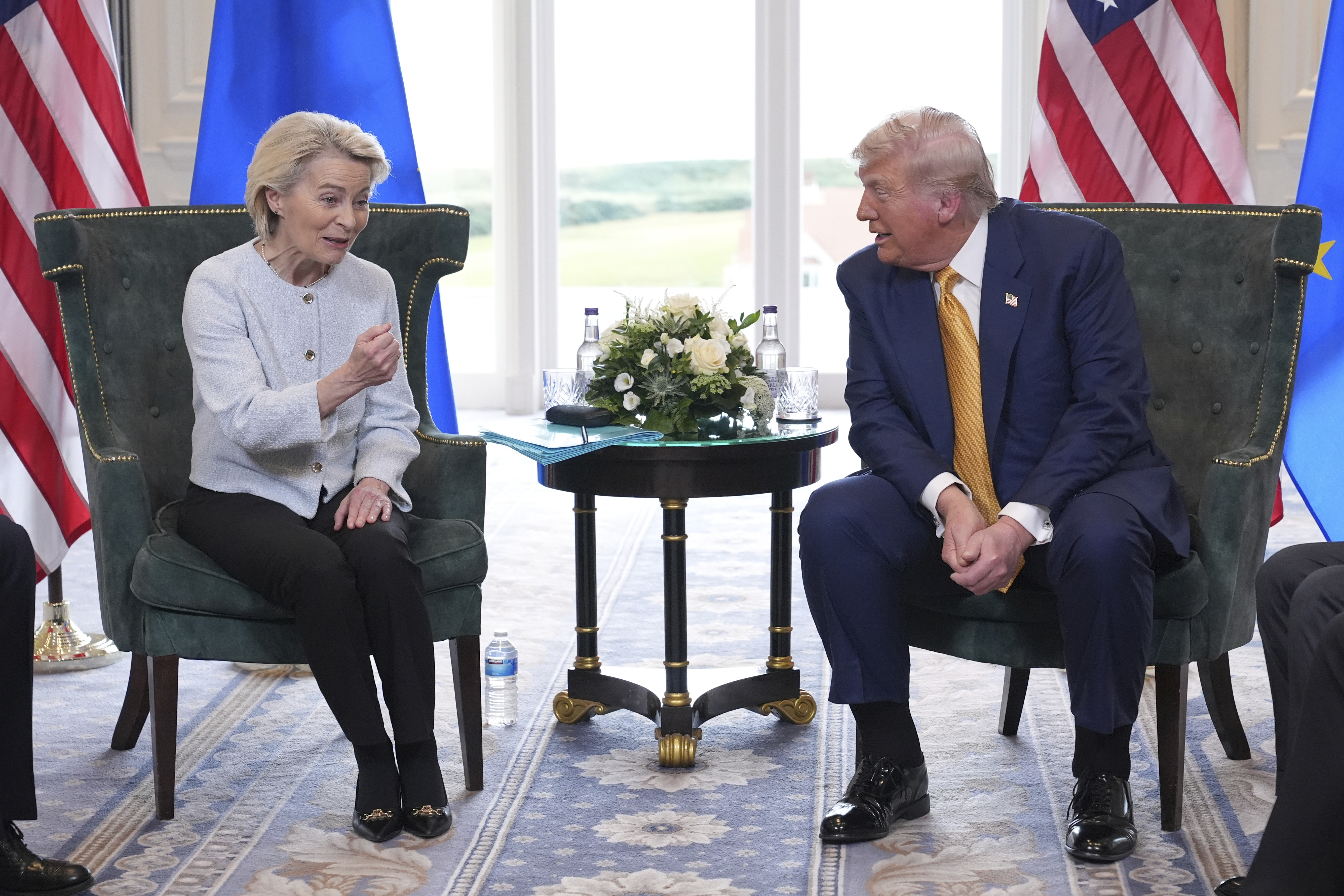 Two political leaders seated during bilateral meeting with US and EU flags