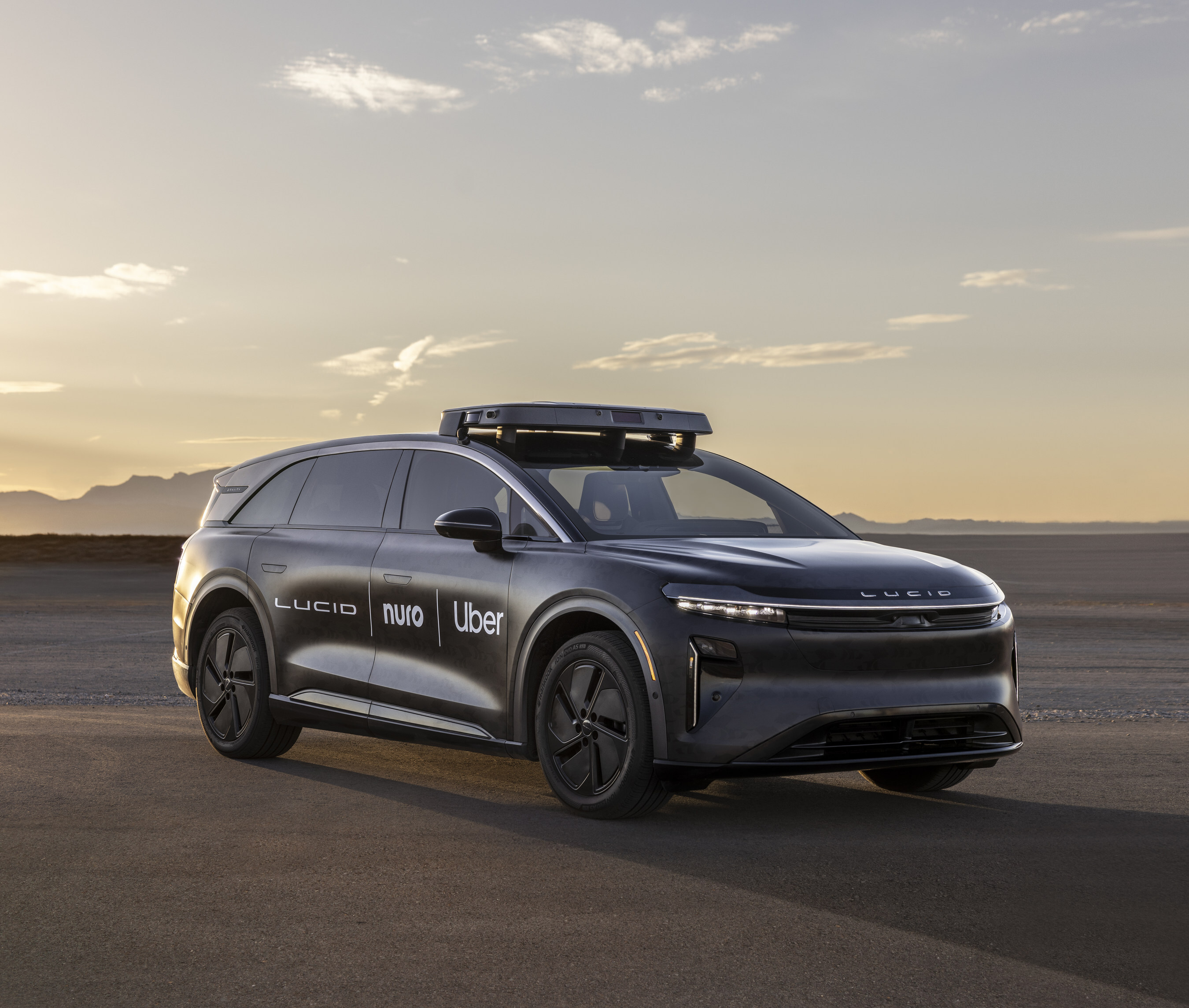 Black Lucid autonomous vehicle with Uber and Nuo branding at sunset