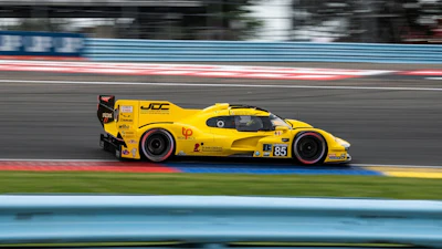 Yellow racing car #85 speeding on professional motorsport track