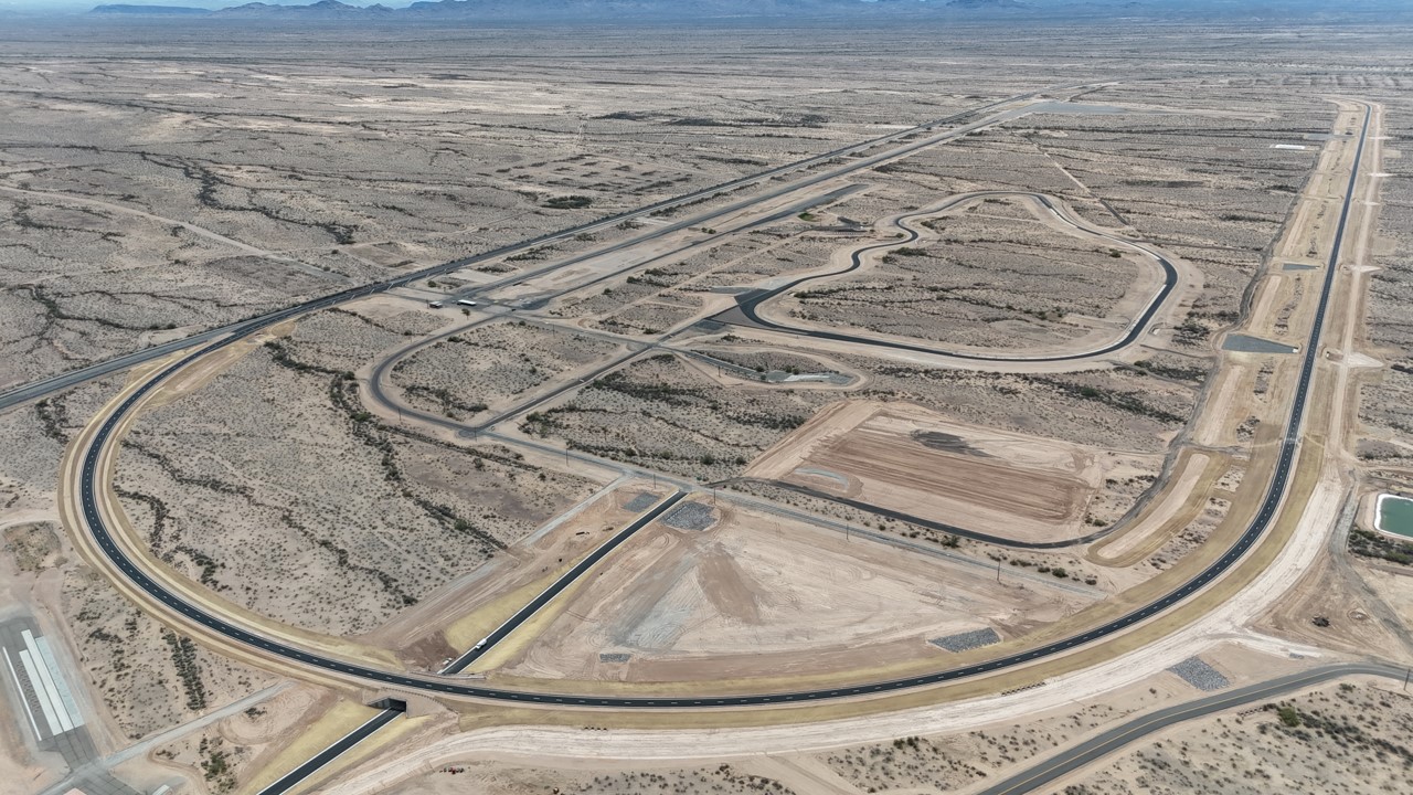 Aerial view of curved racetrack winding through barren desert landscape