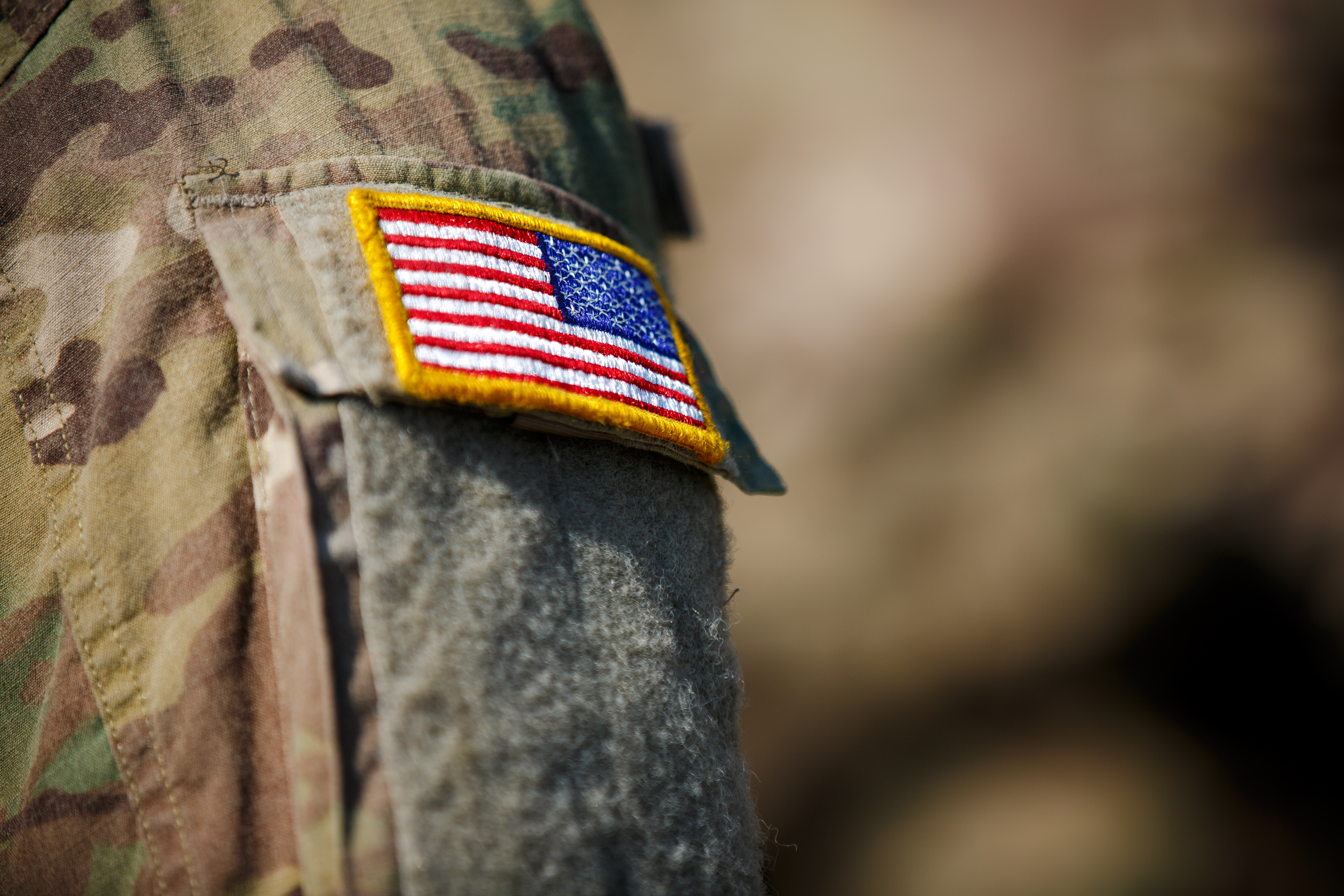 US flag military patch on camouflage uniform sleeve