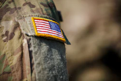 US flag military patch on camouflage uniform sleeve