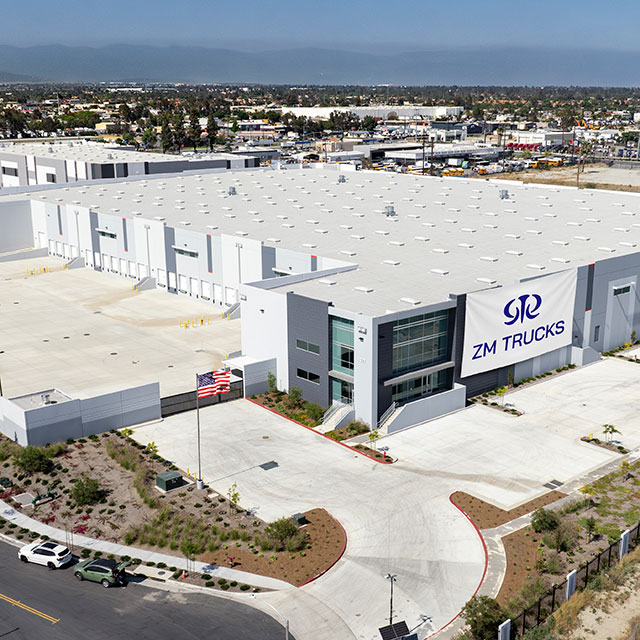 Aerial view of ZM Trucks manufacturing facility with white buildings and parking area