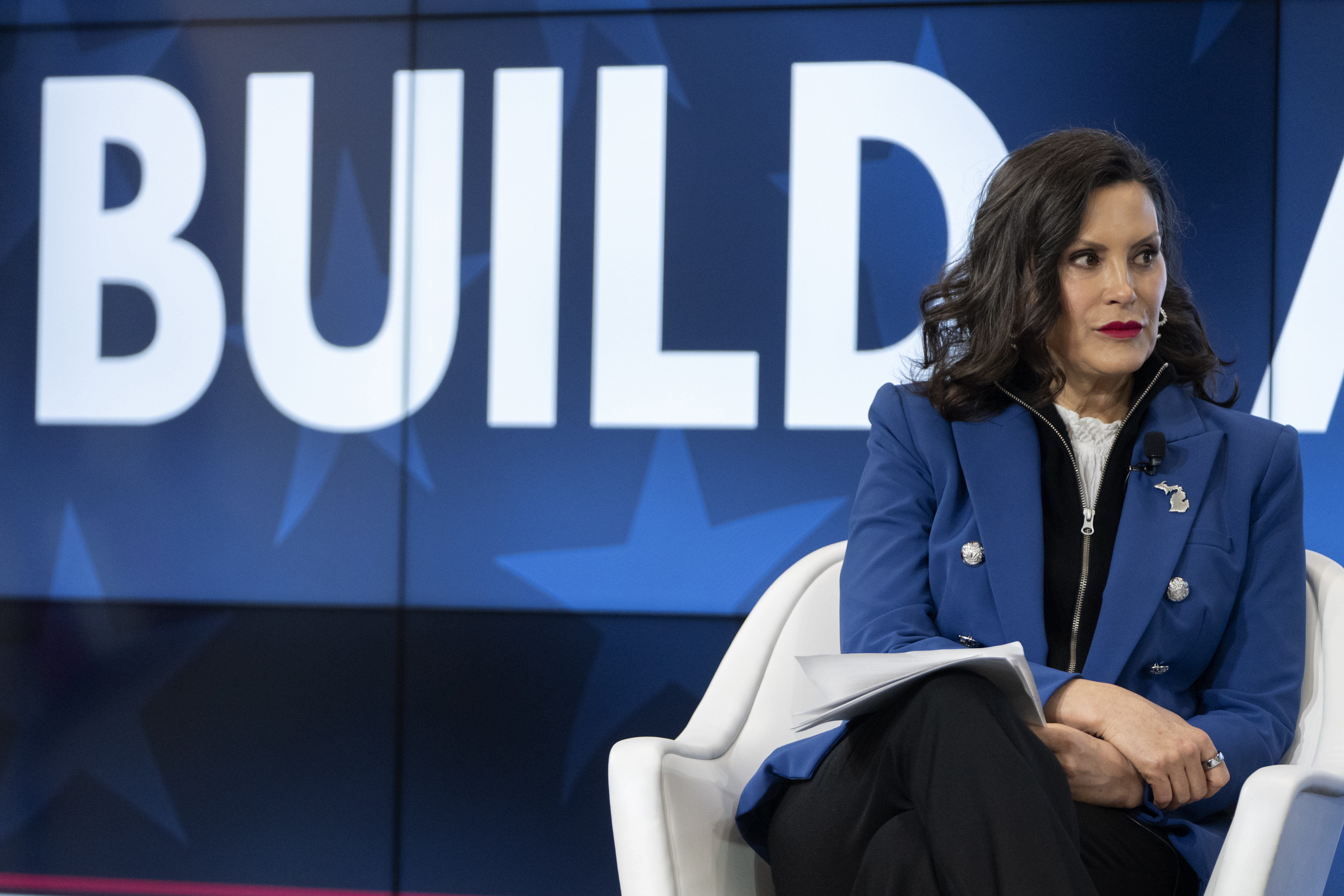 Woman in blue blazer speaking at BUILD conference event on stage