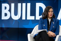 Woman in blue blazer speaking at BUILD conference event on stage