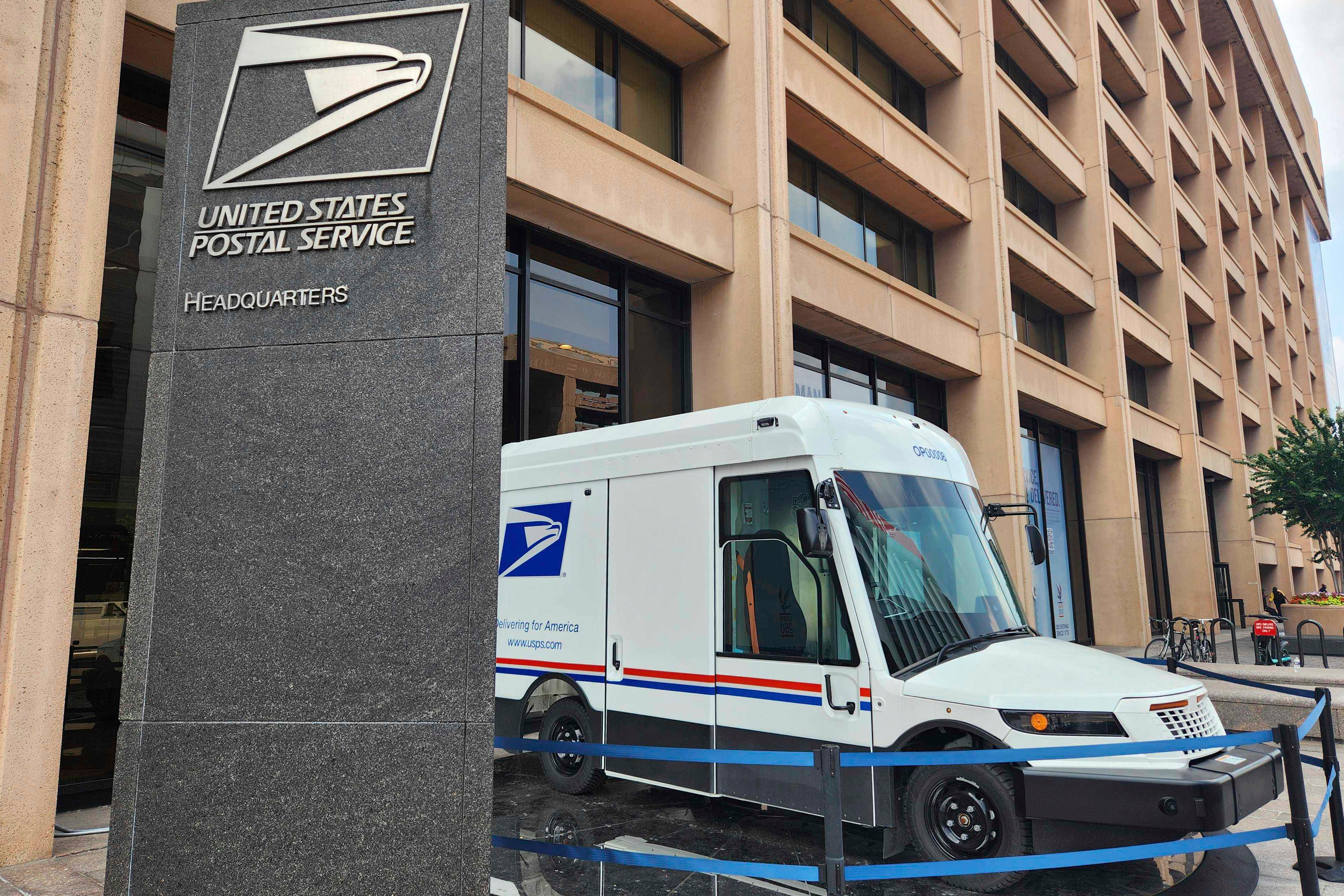 USPS headquarters building with postal delivery truck parked outside