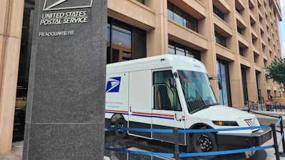 USPS headquarters building with postal delivery truck parked outside
