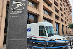 USPS headquarters building with postal delivery truck parked outside