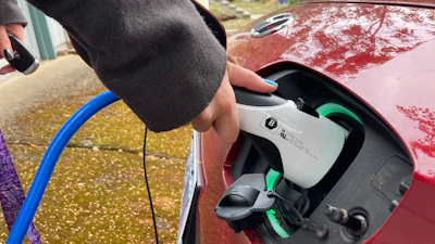 Red electric vehicle being charged with blue charging cable