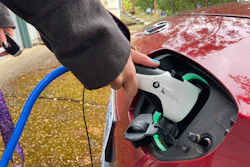 Red electric vehicle being charged with blue charging cable