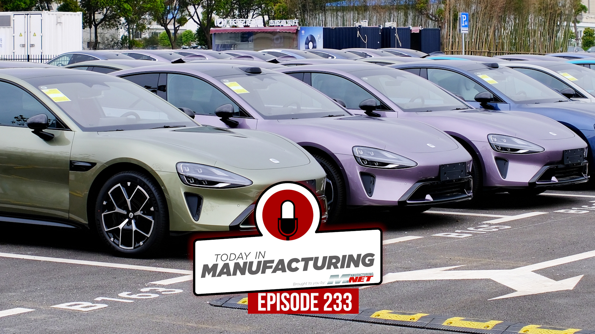 Multiple electric vehicles in green and purple parked in a manufacturing lot