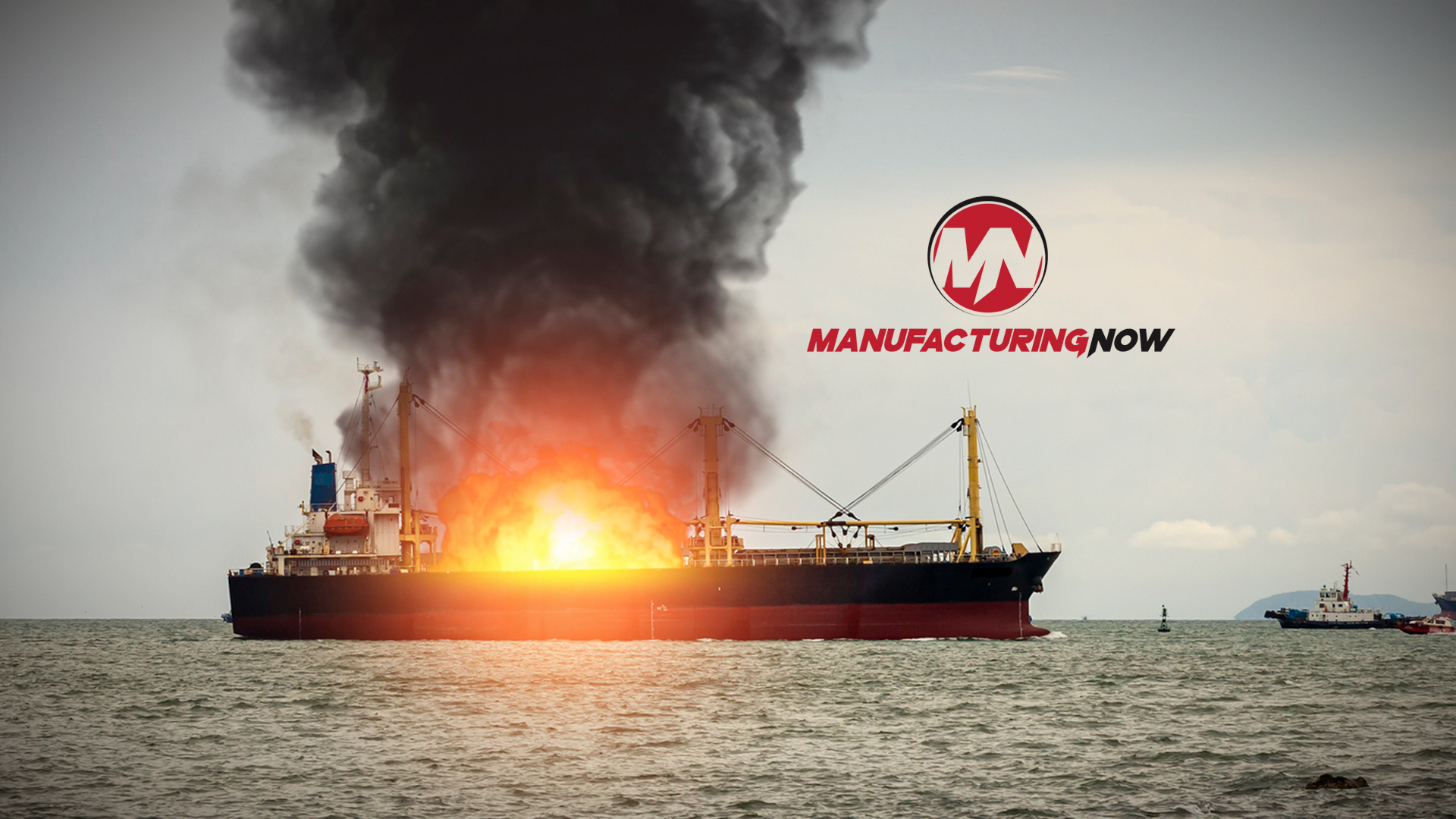 Cargo ship on fire with thick black smoke, Manufacturing Now logo visible