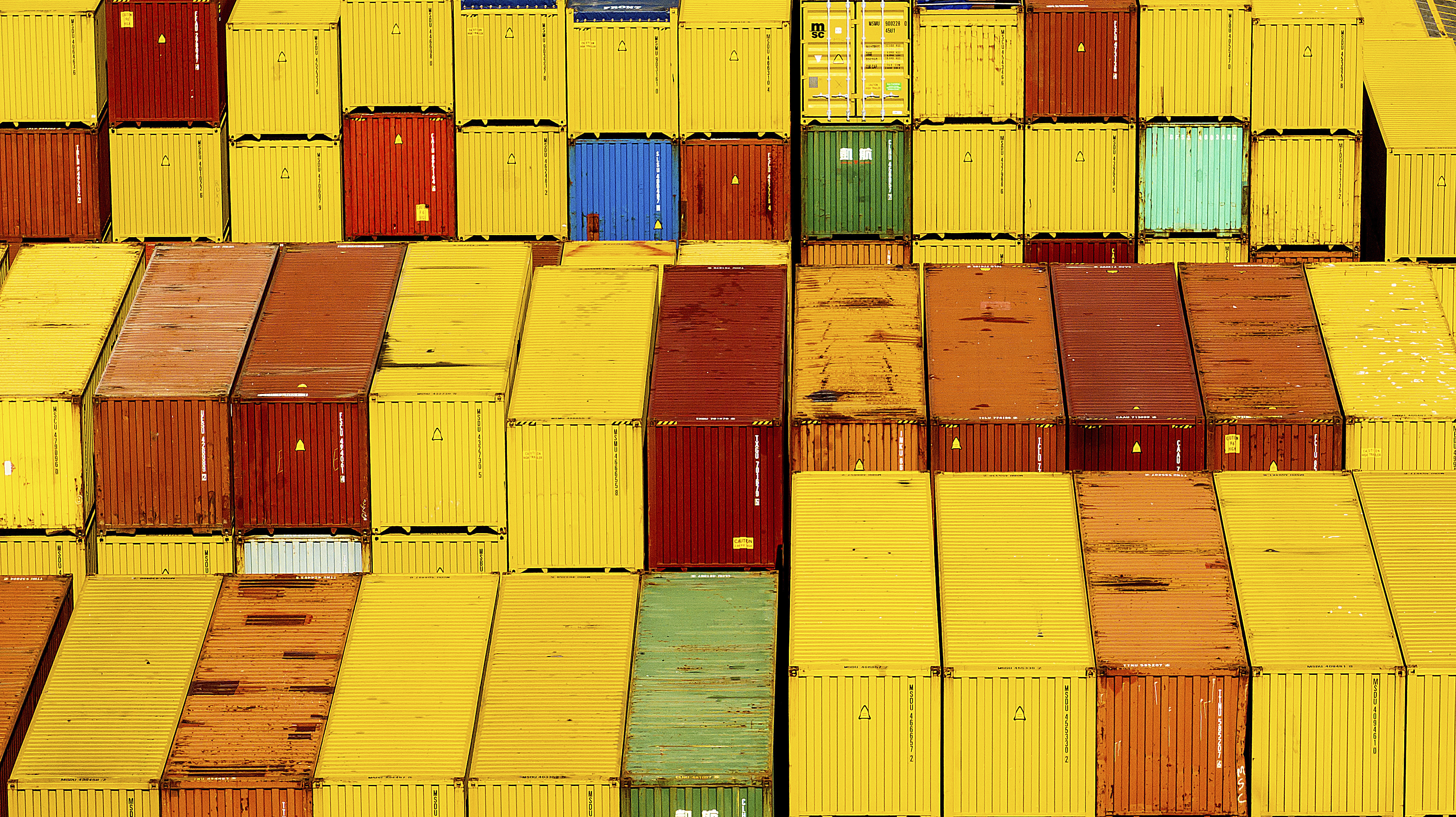 Stacked shipping containers in vibrant yellow, red, and orange colors